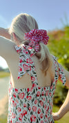 Back view of young blonde woman wearing oversized red gingham scrunchie and Maven Maxi pink & red sundress