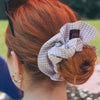 Young red headed woman, hair in bun, wearing Maven Ruffle Scrunchie - beige & white gingham