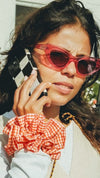 Young mixed heritage boho woman wearing Maven Ruffle Scrunchie - orange & white gingham