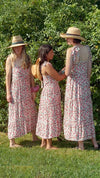 Three diverse young women wearing sun hats in garden wearing red & pink floral Maven Maxi Sundress