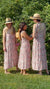Three diverse young women wearing sun hats in garden wearing red & pink floral Maven Maxi Sundress