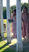 Video of young women in pink floral sundresses with shoulder ties heading for a day out