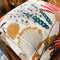 Two floral abstract cushions on chair in browns, reds and blues